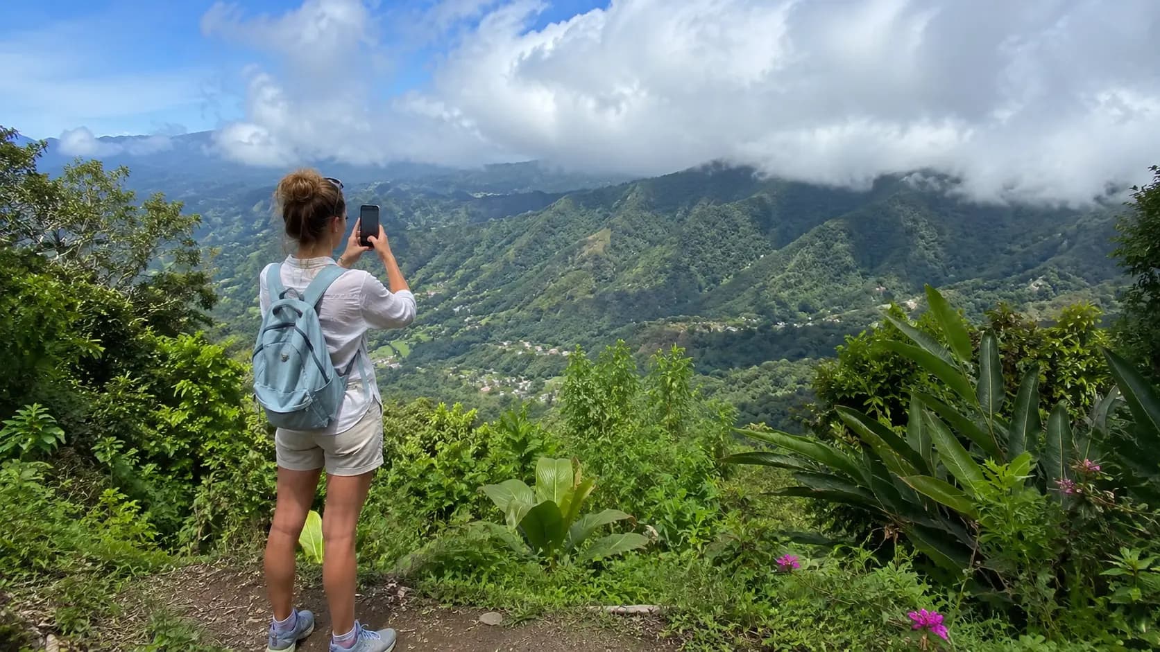A hiker taking a photo of the mountains from a viewpoint at the top of a trail in Panama